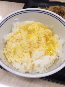 吉野家の牛皿定食のごはんと生卵を卵かけごはんにして食べている写真